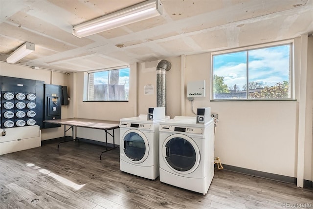 washroom featuring hardwood / wood-style flooring, washer and dryer, and a healthy amount of sunlight