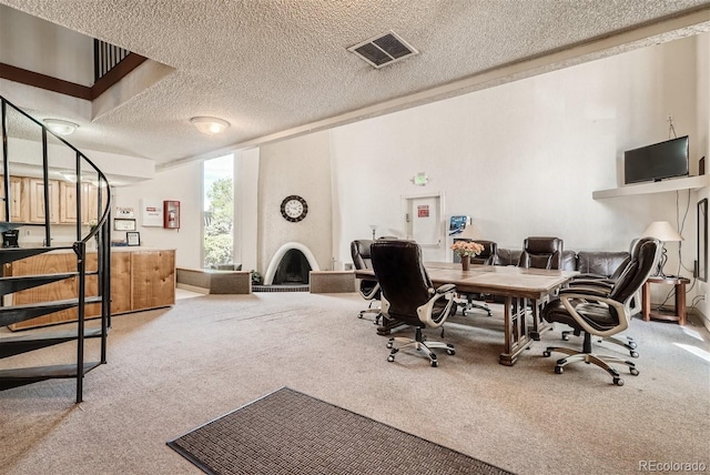 home office featuring a textured ceiling, a large fireplace, and carpet floors