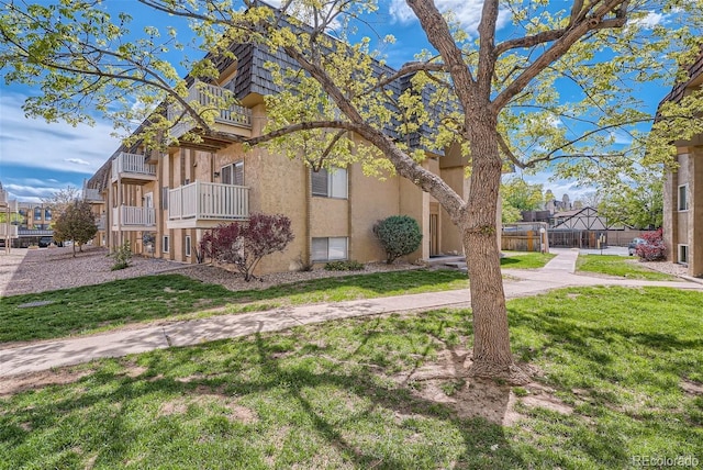 view of property exterior featuring a lawn and a balcony