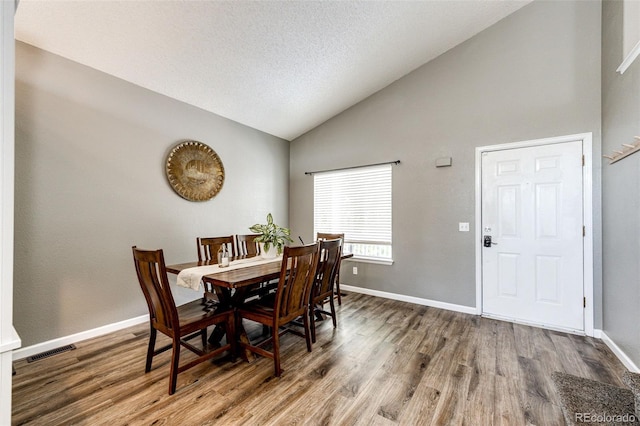 8930 Apache Plume Dr, Parker, CO 80134 - dining area with wood finished floors, high vaulted ceiling, and a textured ceiling