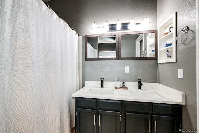 8930 Apache Plume Dr, Parker, CO 80134 - bathroom featuring a textured wall, double vanity, and a textured ceiling