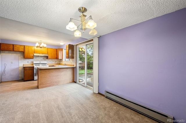 kitchen with a chandelier, white gas stove, a baseboard heating unit, brown cabinets, and under cabinet range hood