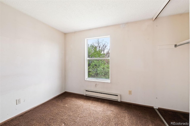 carpeted empty room featuring a baseboard heating unit and a textured ceiling