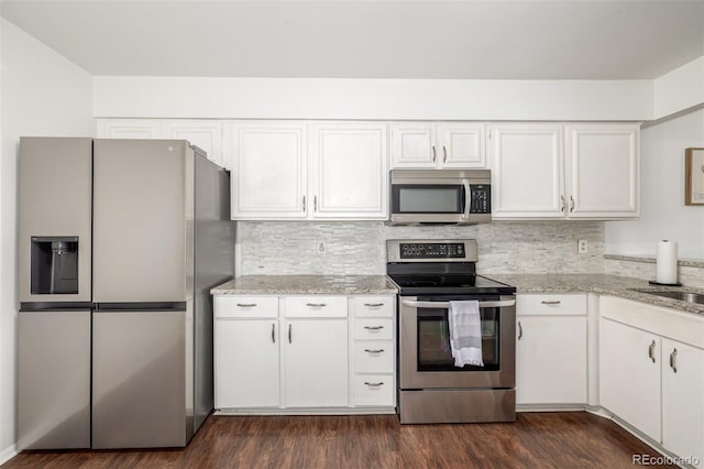 kitchen with stainless steel appliances, dark wood-type flooring, and white cabinetry