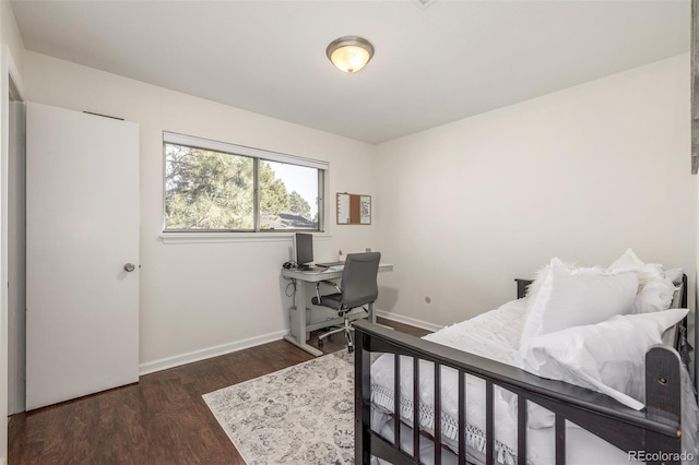 bedroom with baseboards and dark wood-style flooring