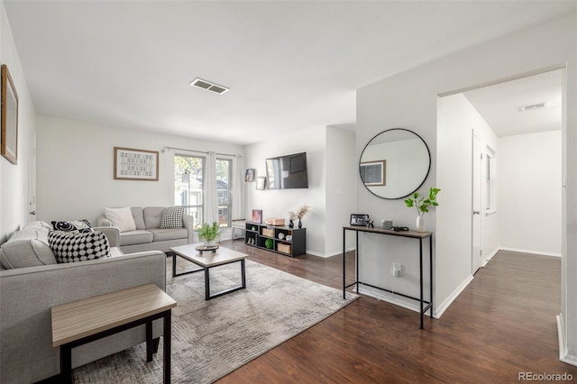 living area with visible vents, baseboards, and wood finished floors