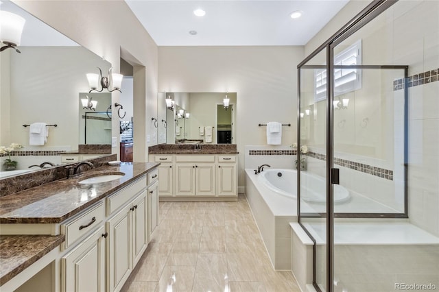 full bath with two vanities, a garden tub, a sink, and a shower stall