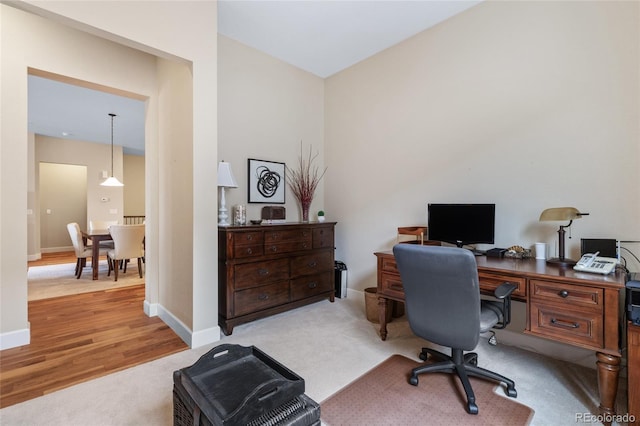 office with carpet floors, wood finished floors, and baseboards