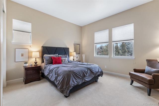 bedroom featuring light colored carpet and baseboards