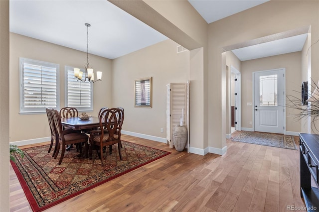 dining room featuring a chandelier, visible vents, light wood-style flooring, and baseboards