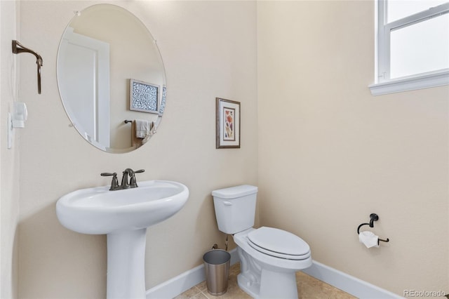 bathroom featuring a sink, tile patterned flooring, toilet, and baseboards