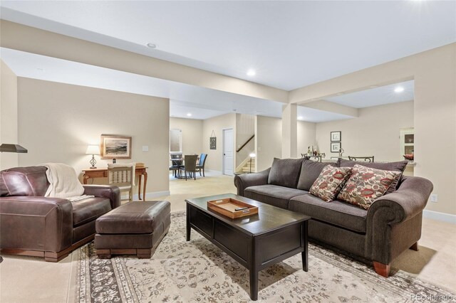 living area featuring stairs, recessed lighting, baseboards, and light colored carpet