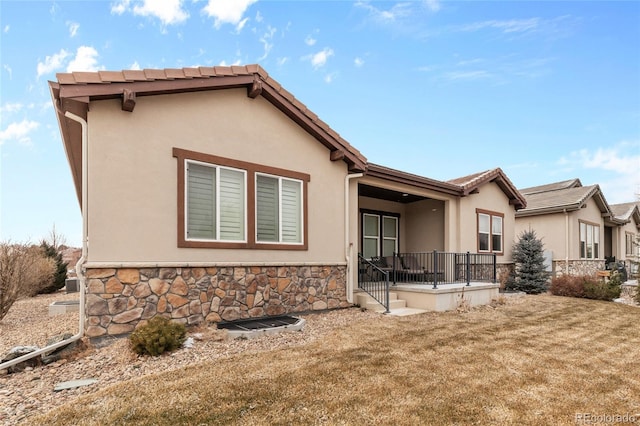 rear view of house with stone siding and stucco siding