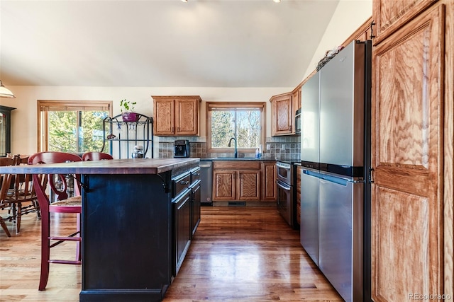 16 Thurber Ct, Fairplay, CO 80440 - kitchen featuring stainless steel appliances, a sink, a kitchen bar, dark countertops, and tasteful backsplash