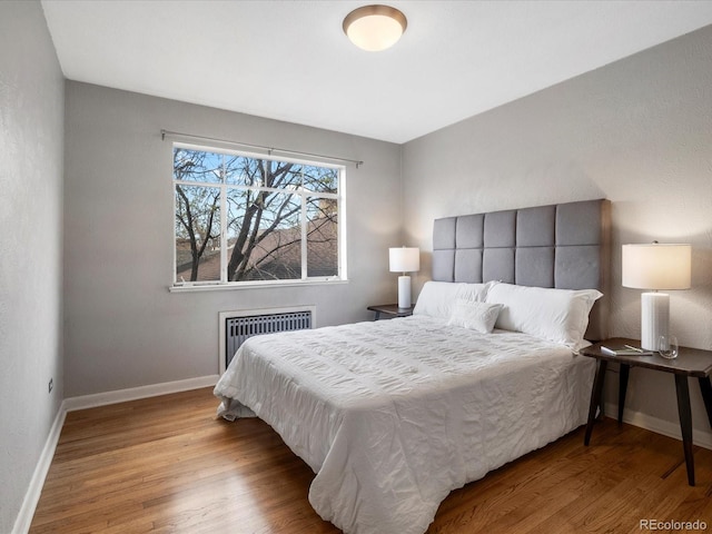 1130 N N Pennsylvania St Unit 306, Denver, CO 80203 - bedroom featuring radiator heating unit and wood finished floors