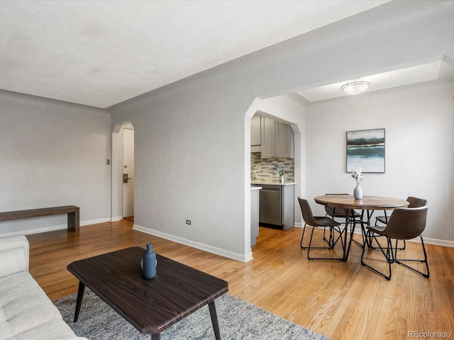 1130 N N Pennsylvania St Unit 306, Denver, CO 80203 - living room featuring arched walkways and light wood finished floors