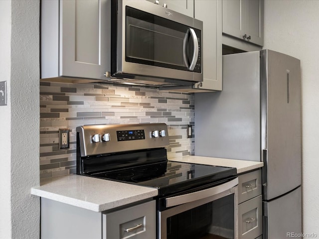 1130 N N Pennsylvania St Unit 306, Denver, CO 80203 - kitchen featuring appliances with stainless steel finishes, gray cabinetry, and decorative backsplash