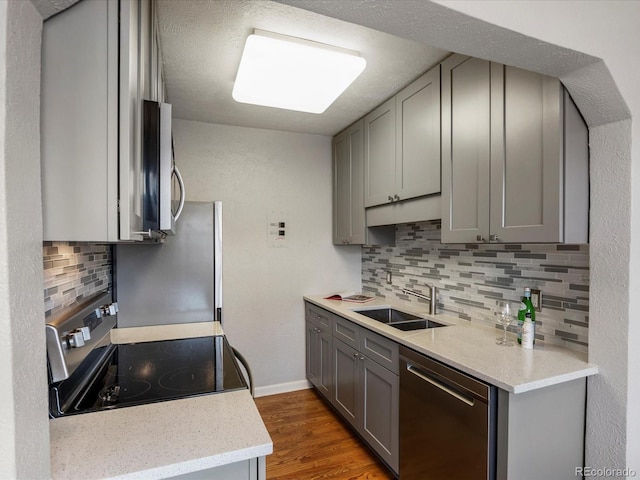 1130 N N Pennsylvania St Unit 306, Denver, CO 80203 - kitchen featuring appliances with stainless steel finishes, gray cabinets, tasteful backsplash, and wood finished floors