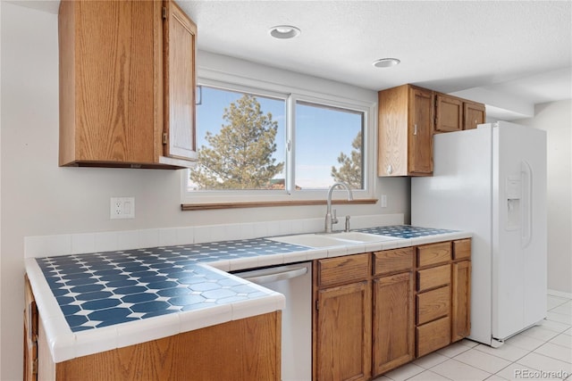 kitchen with dishwasher, white refrigerator with ice dispenser, sink, tile counters, and light tile patterned flooring