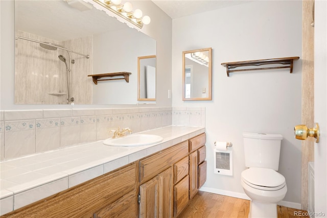 bathroom with tasteful backsplash, vanity, a shower, wood-type flooring, and toilet