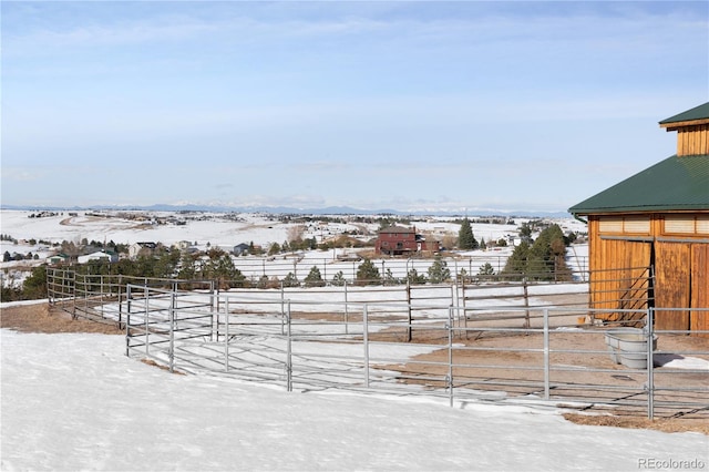 yard covered in snow featuring a rural view and an outdoor structure