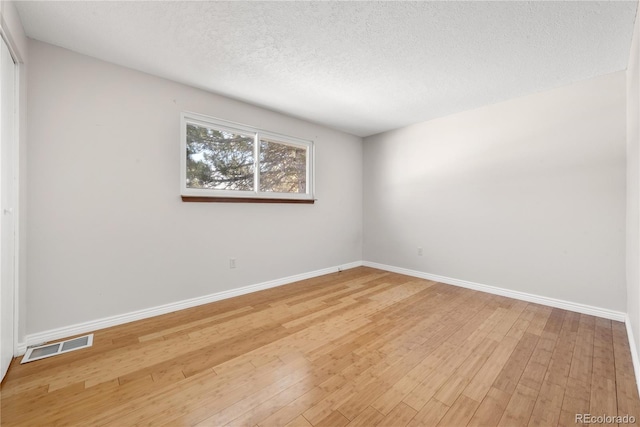 spare room with hardwood / wood-style flooring and a textured ceiling