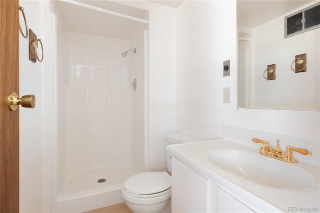 bathroom featuring toilet, vanity, and walk in shower