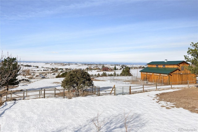 snowy yard with an outbuilding and a rural view