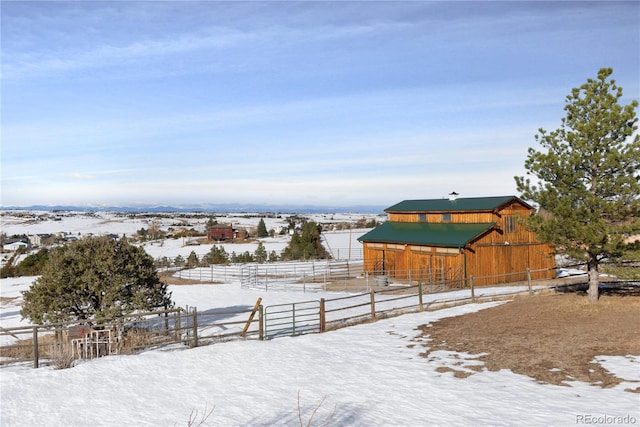 yard layered in snow with a rural view and an outdoor structure