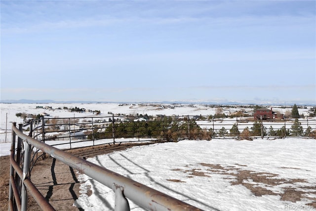 snowy yard with a rural view