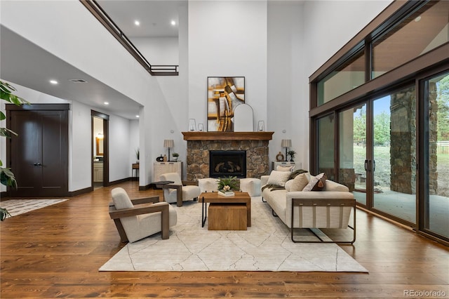 11790 Huckleberry Dr, Franktown, CO 80116 - living room with a high ceiling, light wood-style floors, a stone fireplace, recessed lighting, and baseboards
