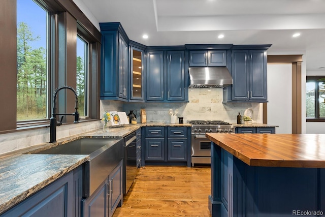 11790 Huckleberry Dr, Franktown, CO 80116 - kitchen featuring butcher block countertops, range hood, appliances with stainless steel finishes, a sink, and backsplash
