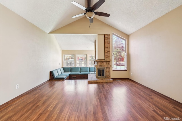 10262 W Ida Ave Unit 243, Littleton, CO 80127 - unfurnished living room featuring ceiling fan, lofted ceiling, a brick fireplace, wood finished floors, and a textured ceiling