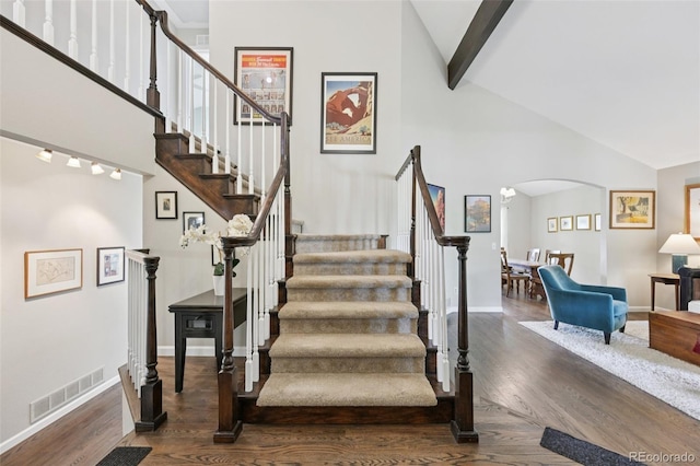 9385 Prairie View Dr, Highlands Ranch, CO 80126 - staircase with arched walkways, high vaulted ceiling, wood finished floors, and beamed ceiling