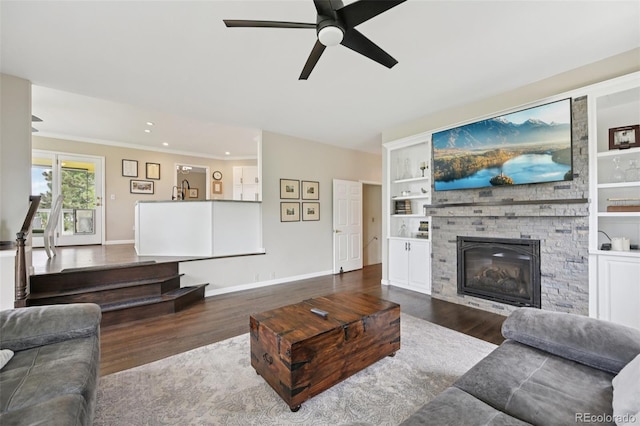 9385 Prairie View Dr, Highlands Ranch, CO 80126 - living area featuring dark wood-style floors, a fireplace, a ceiling fan, recessed lighting, and built in shelves