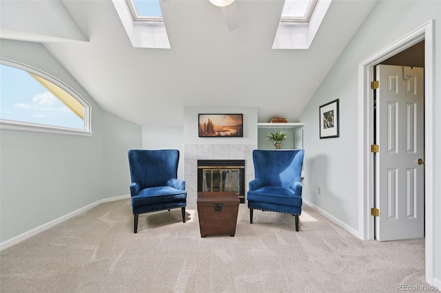 9385 Prairie View Dr, Highlands Ranch, CO 80126 - sitting room featuring a skylight, vaulted ceiling, carpet flooring, a fireplace, and ceiling fan