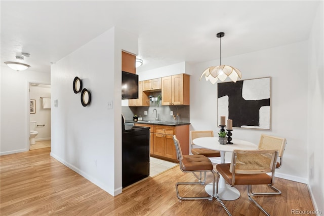 kitchen with sink, stove, hanging light fixtures, backsplash, and light wood-type flooring