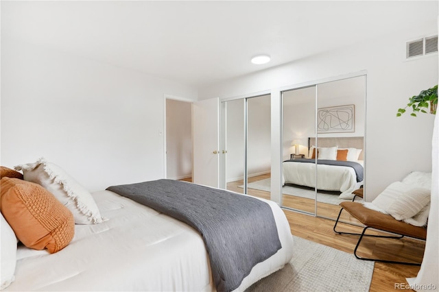 bedroom featuring two closets and hardwood / wood-style floors