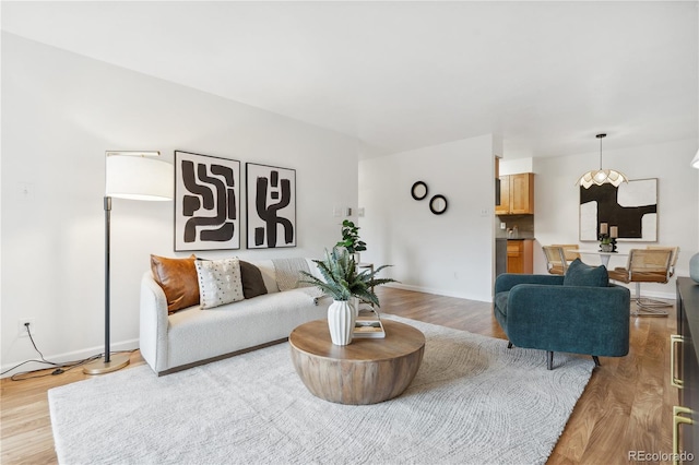 living room featuring light hardwood / wood-style floors and an inviting chandelier