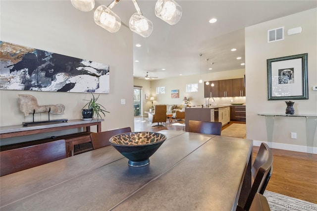 dining room with sink, light hardwood / wood-style floors, and ceiling fan