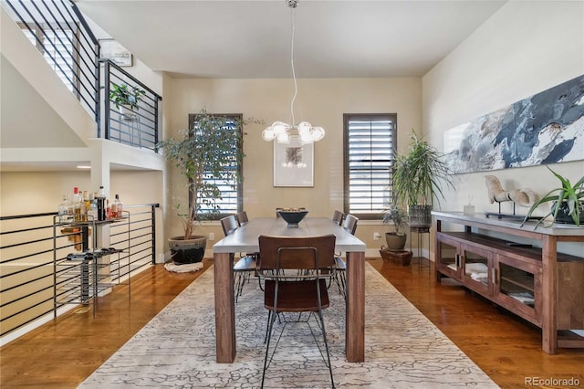 dining room with dark wood-type flooring and a notable chandelier