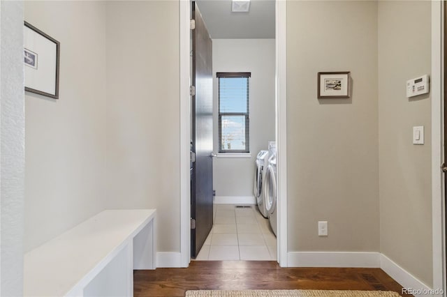 laundry area with separate washer and dryer and light hardwood / wood-style floors