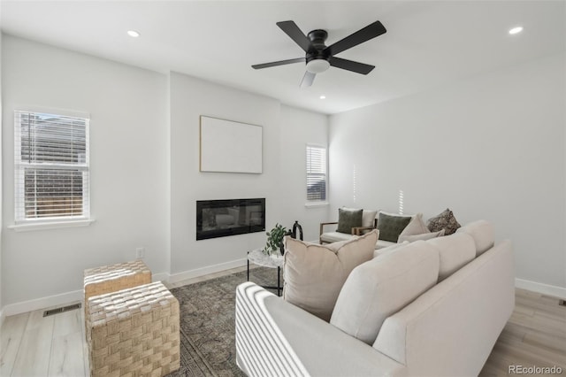 living room with ceiling fan and light hardwood / wood-style flooring