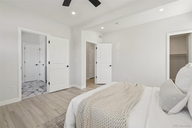 bedroom with ceiling fan, light hardwood / wood-style flooring, and beamed ceiling