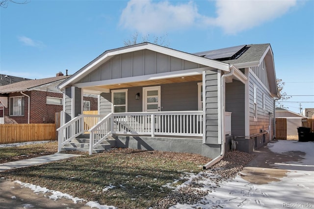 view of front of home with solar panels and a porch