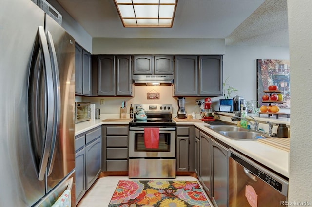 10035 E Mexico Ave, Aurora, CO 80247 - kitchen with stainless steel appliances, a sink, under cabinet range hood, and light countertops