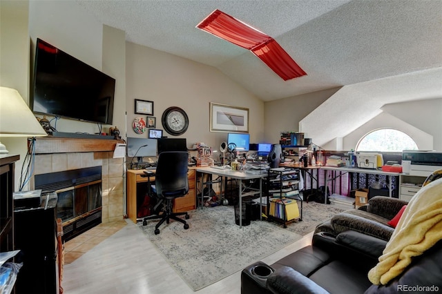 10035 E Mexico Ave, Aurora, CO 80247 - office featuring lofted ceiling, a tile fireplace, a textured ceiling, and wood finished floors