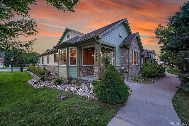 property exterior at dusk featuring a yard