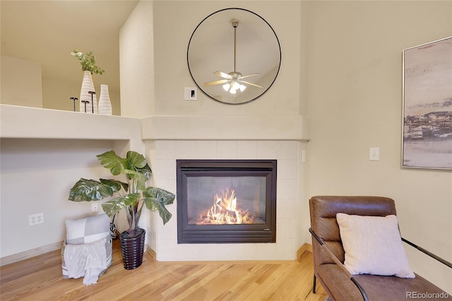 interior details featuring hardwood / wood-style flooring, ceiling fan, and a tile fireplace