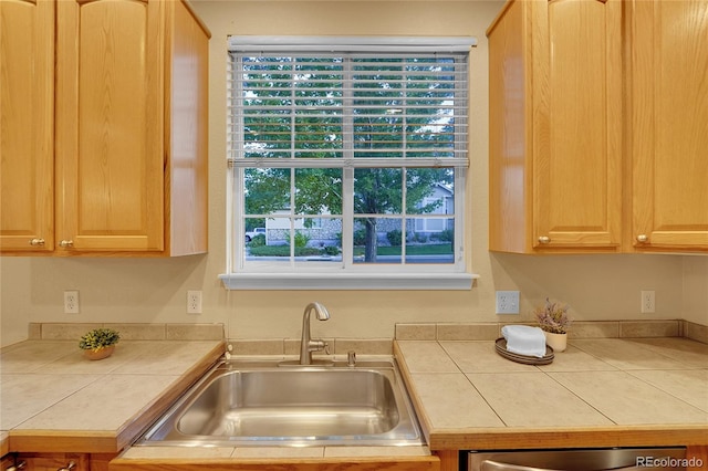 kitchen with dishwasher, sink, tile countertops, and light brown cabinetry